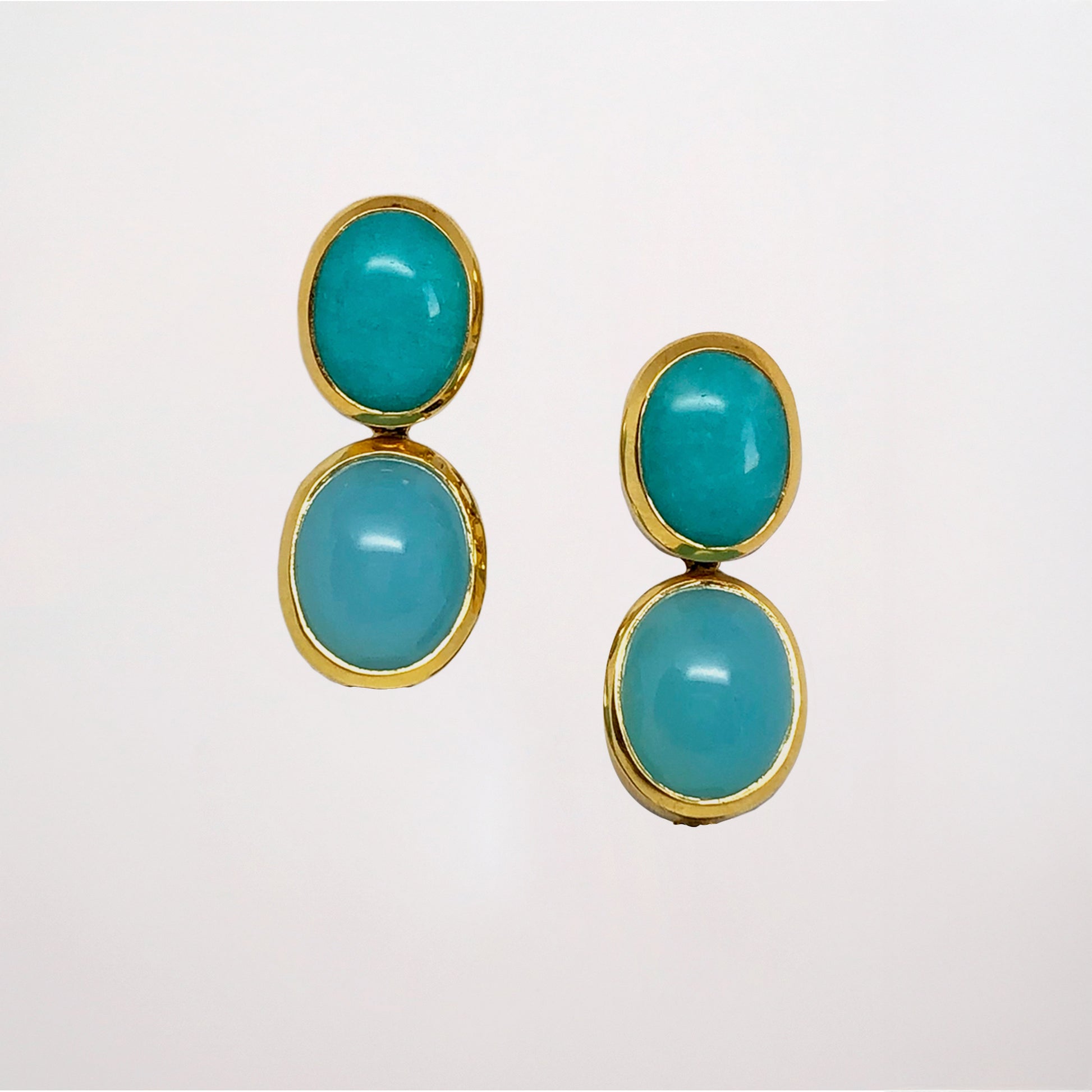 Amazonite and chalcedony blue gemstone earrings set in yellow gold on a light gray background