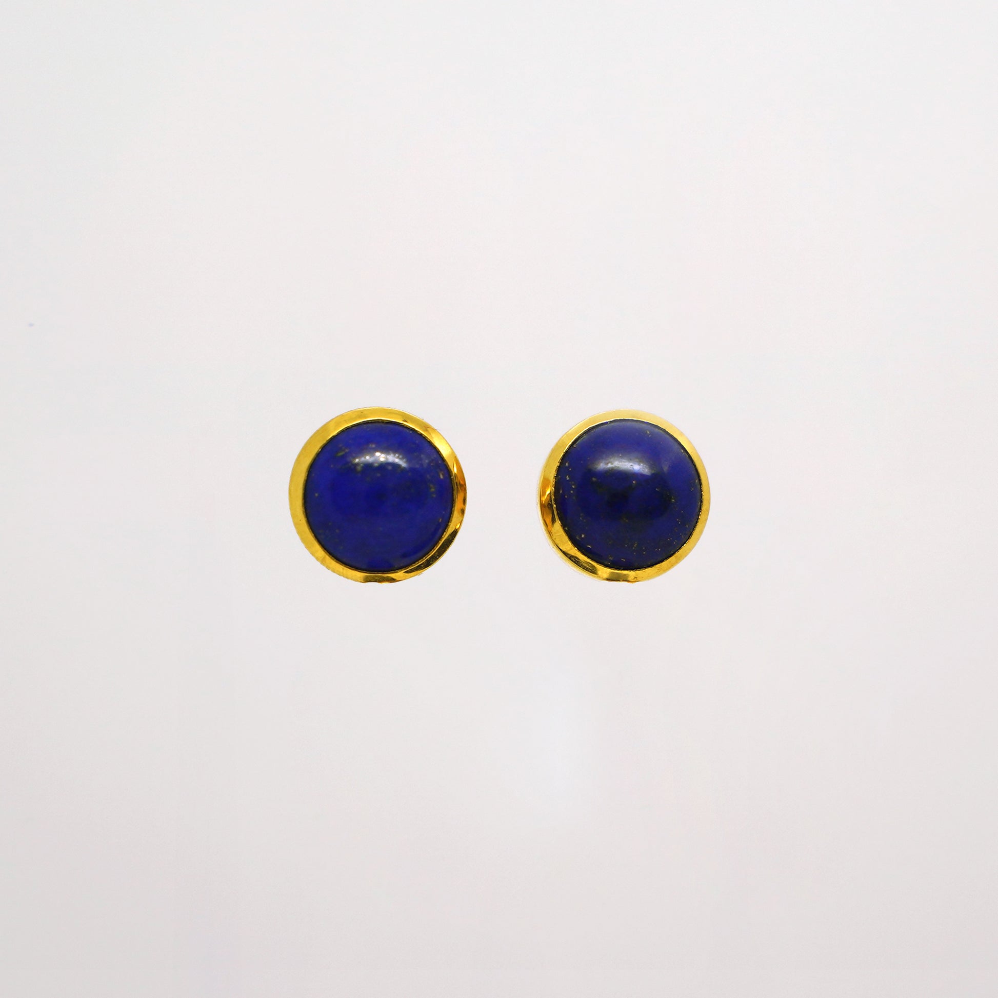 Pair of round blue lapis lazuli studs with gold rims on a white background
