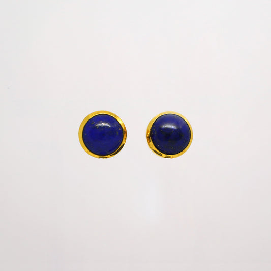 Pair of round blue lapis lazuli studs with gold rims on a white background
