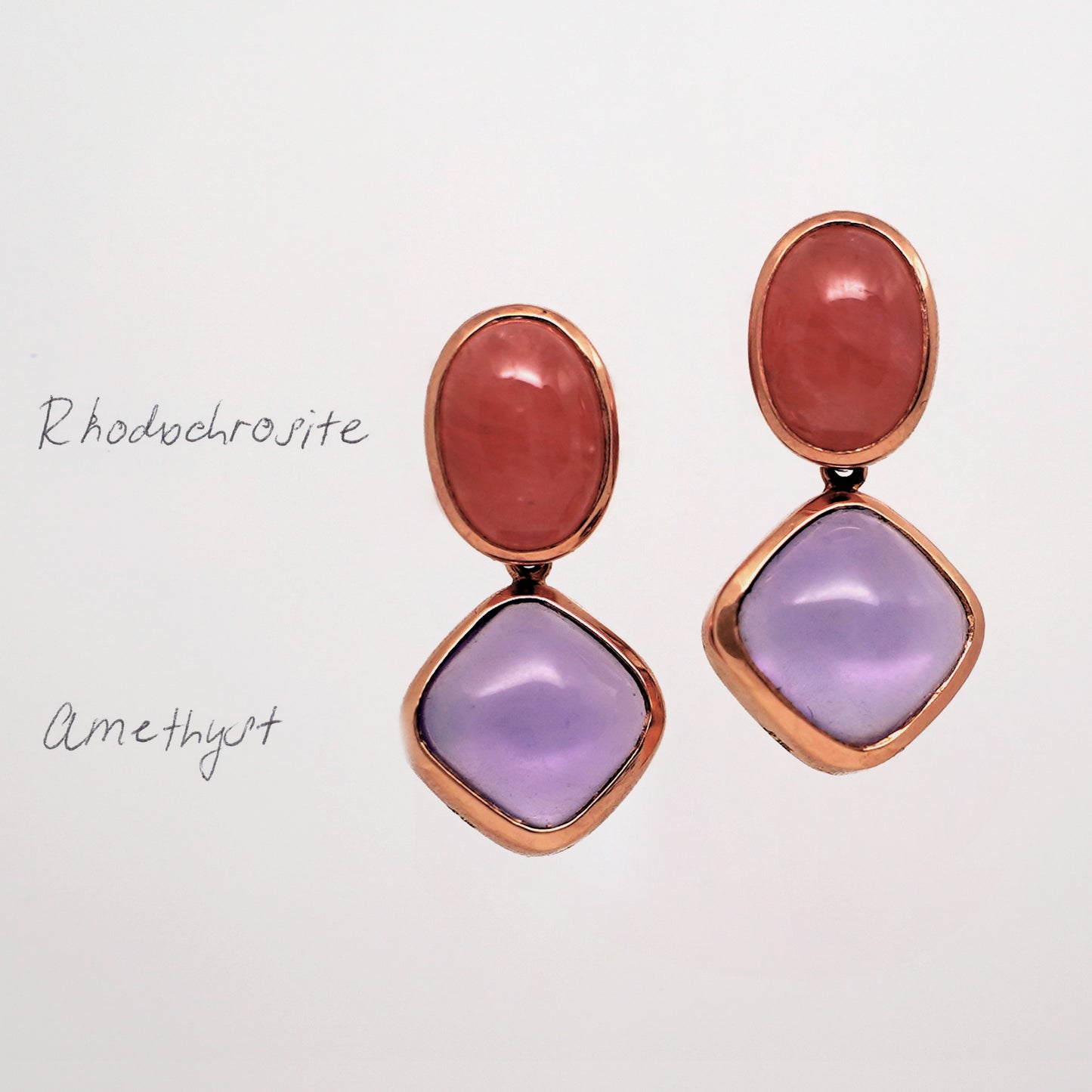 Rhodochrosite and Amethyst Gemstone Stud Earrings. Pair of earrings with pink and purple stones in rose gold on a light gray background